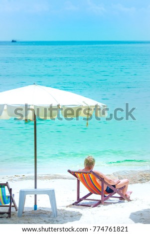 Man relaxing sitting on the beach chairs.
