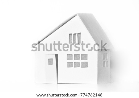 Small white cardboard houses on white background. Handmade home winter decoration. Do it yourself. Architecture business real estates concept. Shallow depth of focus.