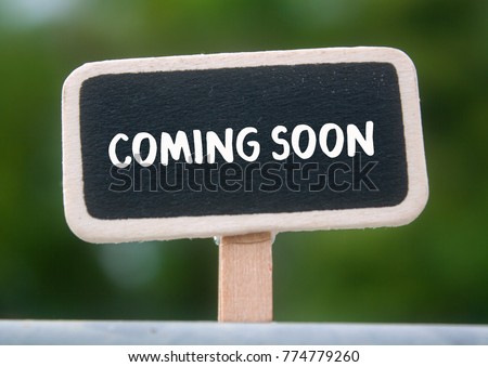 Wooden tag written coming soon over blurred background