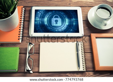 Business workplace with office stuff and tablet with padlock icons on screen