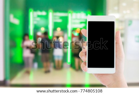 woman use mobile phone and blurred image of people at the ATM machines