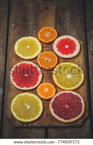 slices of different varieties of citrus fruits on the table (background)
