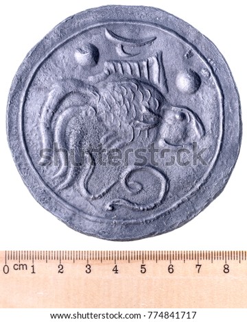 Ancient tin-zinc coin of Funan with a picture of a goldfish and a snake. Obverse. Isolated on white