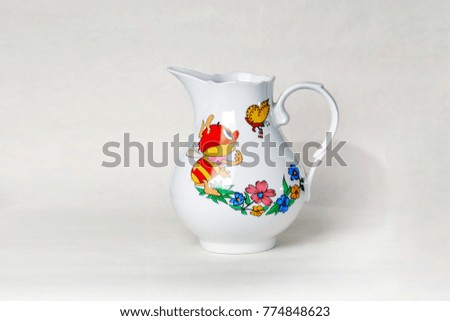 White ceramic pitcher with picture of a bee and a butterfly isolated on white background.