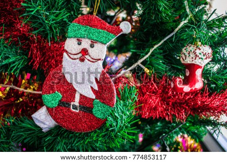 The Christmas tree is a decorated evergreen coniferous tree with Santa Claus symbol and multi color led light