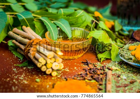 Close up of ingredients of ayurvedic treatment i.e neem,neem leaves,neem powder,bark,clove,turmeric,water. Royalty-Free Stock Photo #774865564