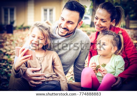 Get smile to do camera, Girl take a picture of all family. Outside. 