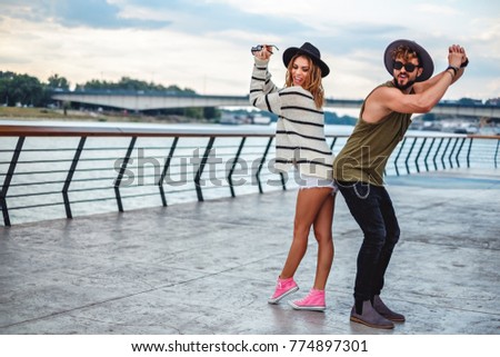 Hipster couple dancing and having fun by the river