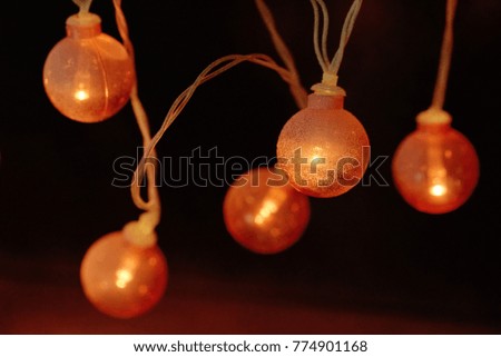 Electric garland with red bulbs gleam in a dark.