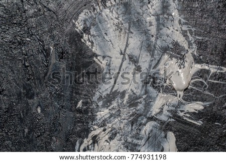 iron surface is covered with remnants of old paint white and black colors, background texture
