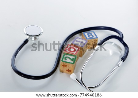 Colorful Wood block 2018 with medical stethoscope isolated white background New year new heatlh concept