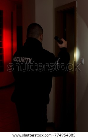 Security man, checks in the dark with flashlight