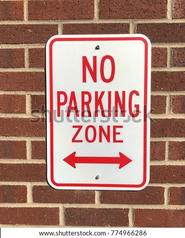 No parking sign and brick wall