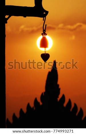 Thai bell hanging in front of the Temple in Bangkok silhouette background