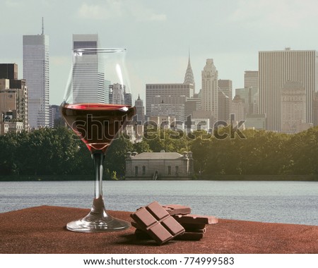 Red wine glass with chocolate and New York skyline