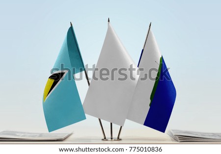 Flags of Saint Lucia and Navassa Island with a white flag in the middle