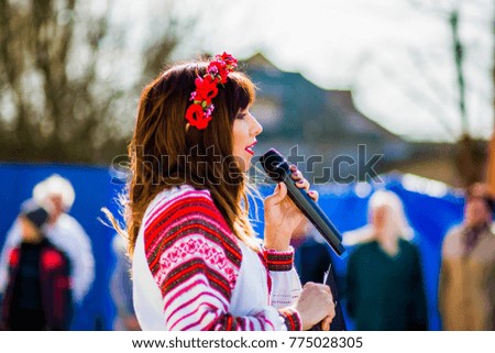 Girl with a microphone speaks to viewers Royalty-Free Stock Photo #775028305