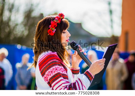 Girl with a microphone speaks to viewers Royalty-Free Stock Photo #775028308