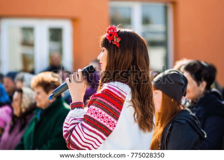 Girl with a microphone speaks to viewers Royalty-Free Stock Photo #775028350
