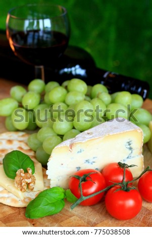 cheese tomato and grapes on the table with red wine and bottle no people stock photo