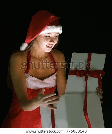 beautiful woman dressed as Santa Claus, opening the box with hi