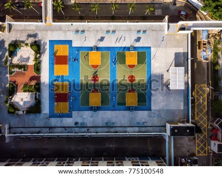 drone view of people playing in colorful basketball courts from above in Hong Kong