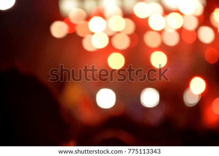 Between people with blurry stage lighting and soft red bokeh background 