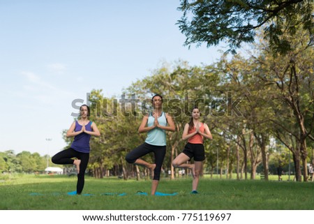 Activities in family, mother and daughter on a yoga mat to relax in the park outdoor, Concept of healthy lifestyle and relaxation.