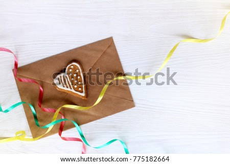 kraft envelope with ginger cookies in the shape of heart and color serpentine top view / congratulatory with the day of all lovers