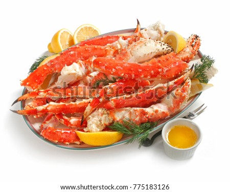 Alaskan King Crab legs on platter, served with lemon and butter, on white background Royalty-Free Stock Photo #775183126