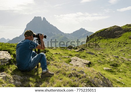 man hiker with camera and taking picture of beautiful mountain