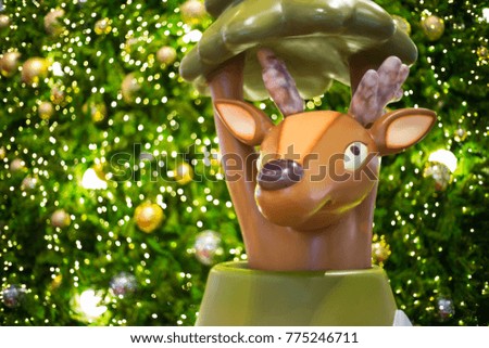 A brown deer is in front of Christmas tree with the light