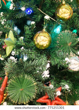 Green christmas tree background wallpaper with golden balls and another decoration, picture in vertical line.