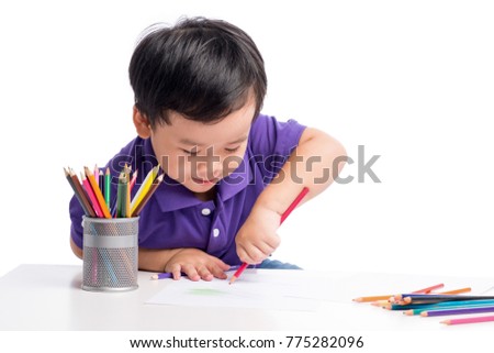 Portrait of cheerful boy drawing with colorful pencils