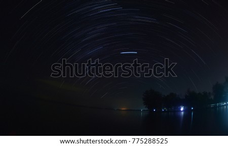 stars trail overs the river and sea on clear sky night