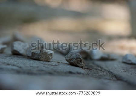 stones in the foreground and blur in the background, stones are light grey and the background grey and  orange colors, stones are in a group, the focus is on two stones and the others are blur  Royalty-Free Stock Photo #775289899