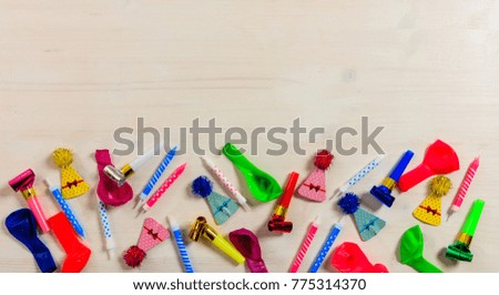 Colorful birthday party supplies on wooden background, top niew and copy space