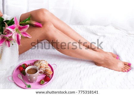 Comfort Concept - Woman drinking hot cocoa. Close-up of female legs in bright colored warm socks