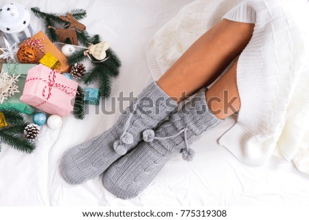 Soft photo of woman in knitted socks with christmas gifts , top view point