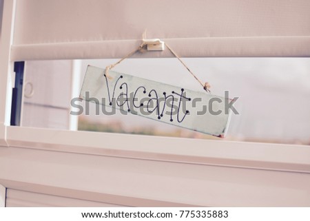 Indoor Vacant sign in a beach hut window 