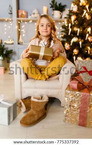 Image of girl sitting in chair on background of Christmas decorations