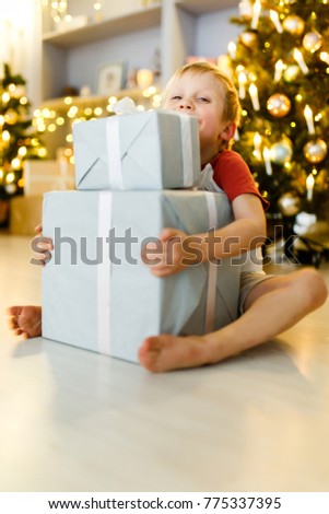 New Year's picture of boy with gift box on background of Christmas decorations