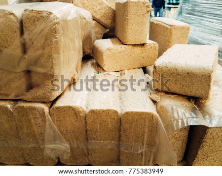 Alternative fuel, eco fuel, bio fuel. Wood sawdust briquettes for stoves. Lean-burn with good heat output. Briquettes from sawdust on a green background. Royalty-Free Stock Photo #775383949