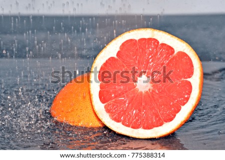 grapefruit in the rain in front of a black background