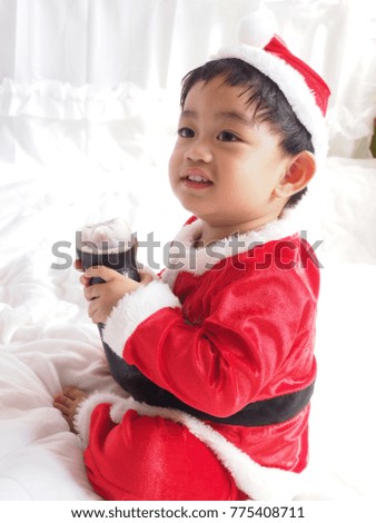 A happy little boy in a red santa suit