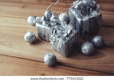 Top view image of silver present boxes and Christmas decorations on wooden 
background