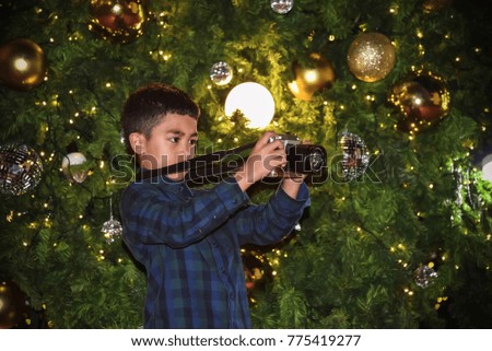 Cute Asian boys are watching and taking pictures, lights, Christmas balls decorated with Christmas trees, festivals of happiness.
