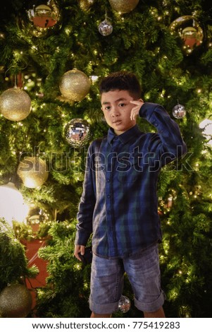 Cute Asian boys are watching and taking pictures, lights, Christmas balls decorated with Christmas trees, festivals of happiness.