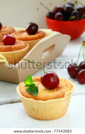 mini cheese cake with cherries and mint on a wooden table