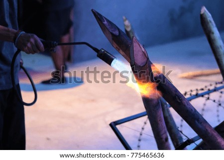 Gas burner lighting a piece of wood in a fire pit. Blowtorch setting wood on fire in a fireplace. Wood burning in the pit.